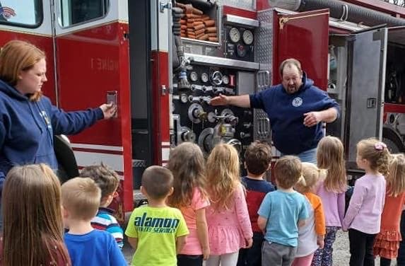 Fire company vice-president and line officer/firefighter Russell Yerkes shows a group of youngsters where everything is located in a modern-day fire apparatus, during a 2020 Fire Prevention Week demonstration at the Damascus School.